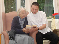 Carer reading with resident 